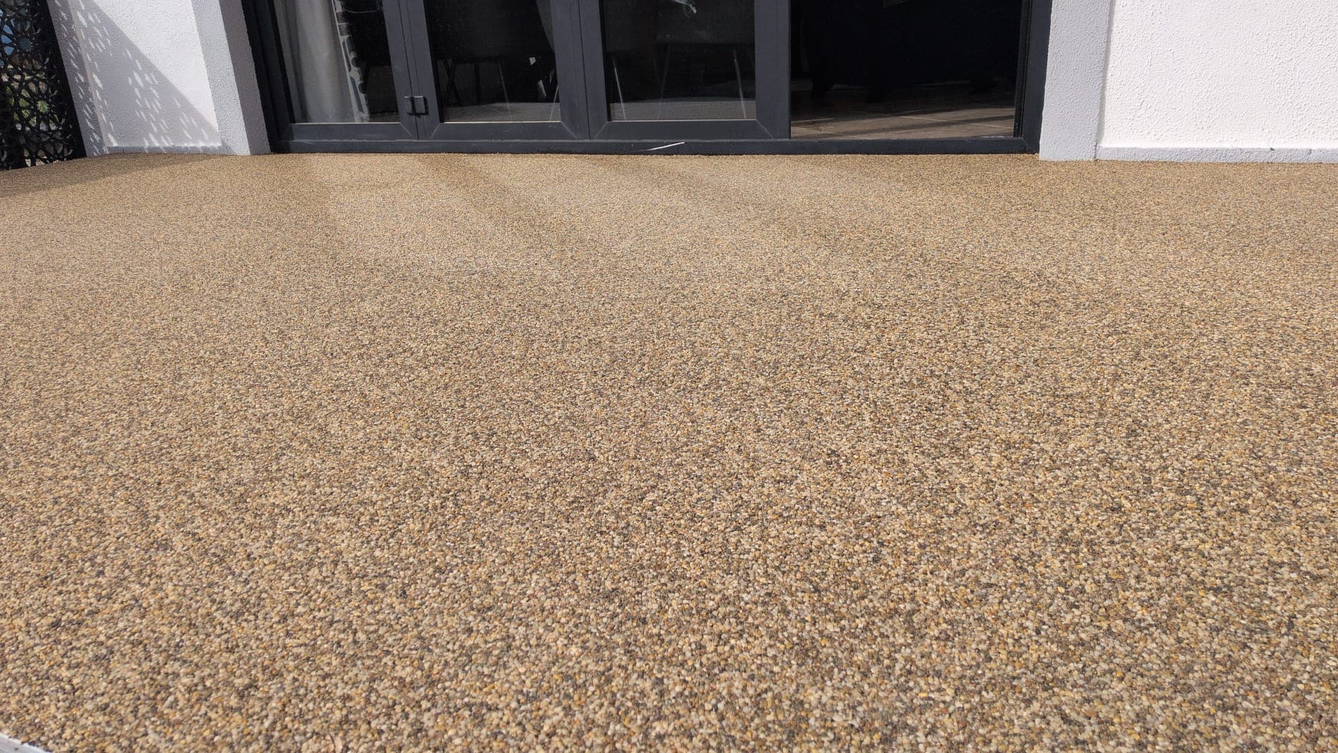 Resin Bound Patio, Buff Finish — A buff-finish patio laid flush to the bifold doors for a seamless indoor-outdoor flow.