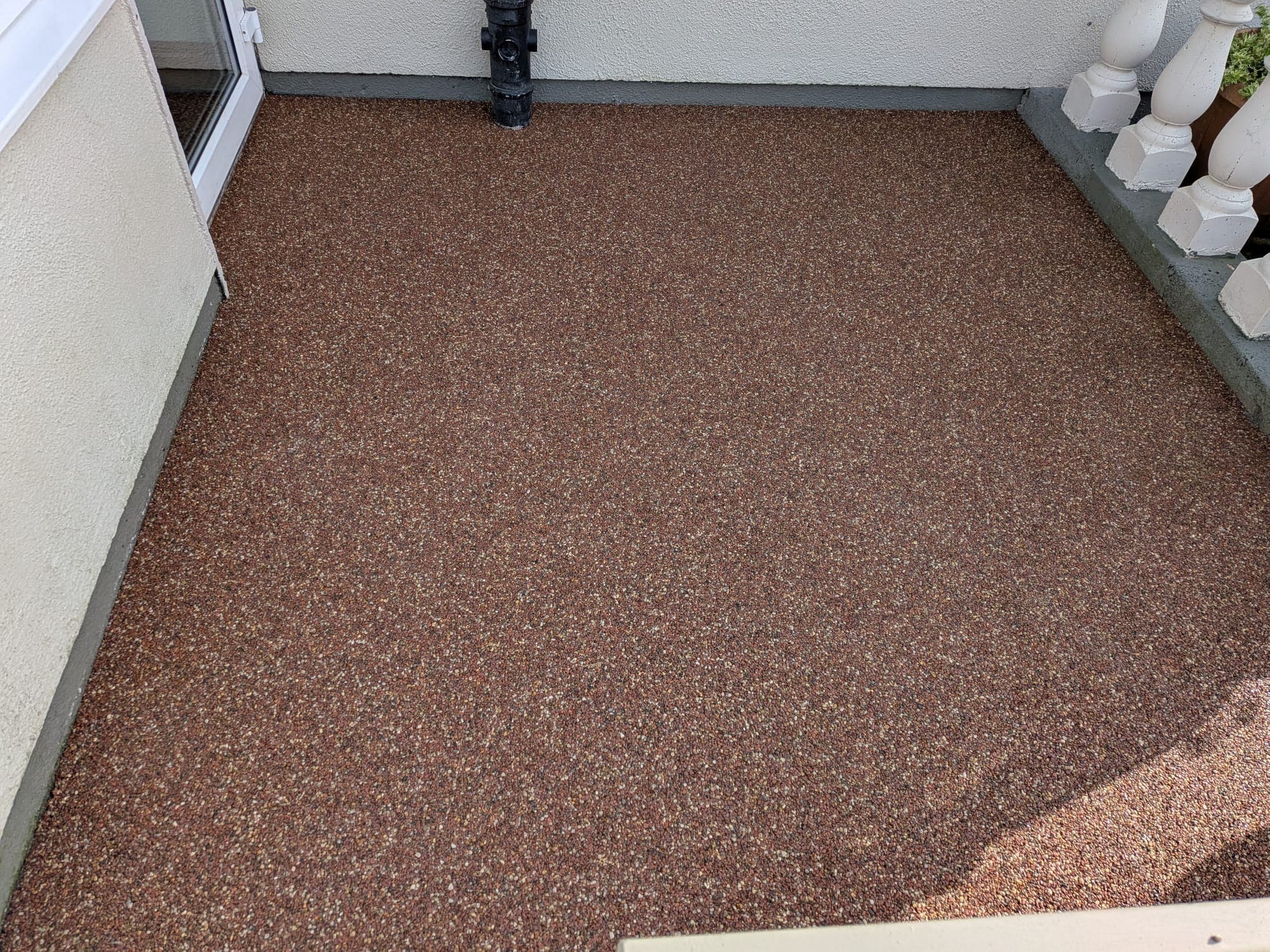 Resin Bound Patio, Curved Design — A curved terracotta patio with a granite border, laid to the sliding doors.